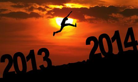 Silhouette of a man jumping from 2013 towards 2014 year at sunset